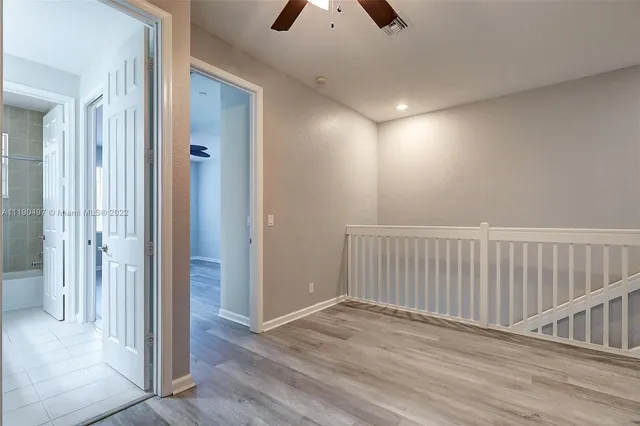 a view of a hallway with wooden floor and entryway