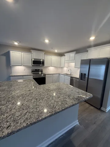 a kitchen with stainless steel appliances granite countertop a sink stove and refrigerator