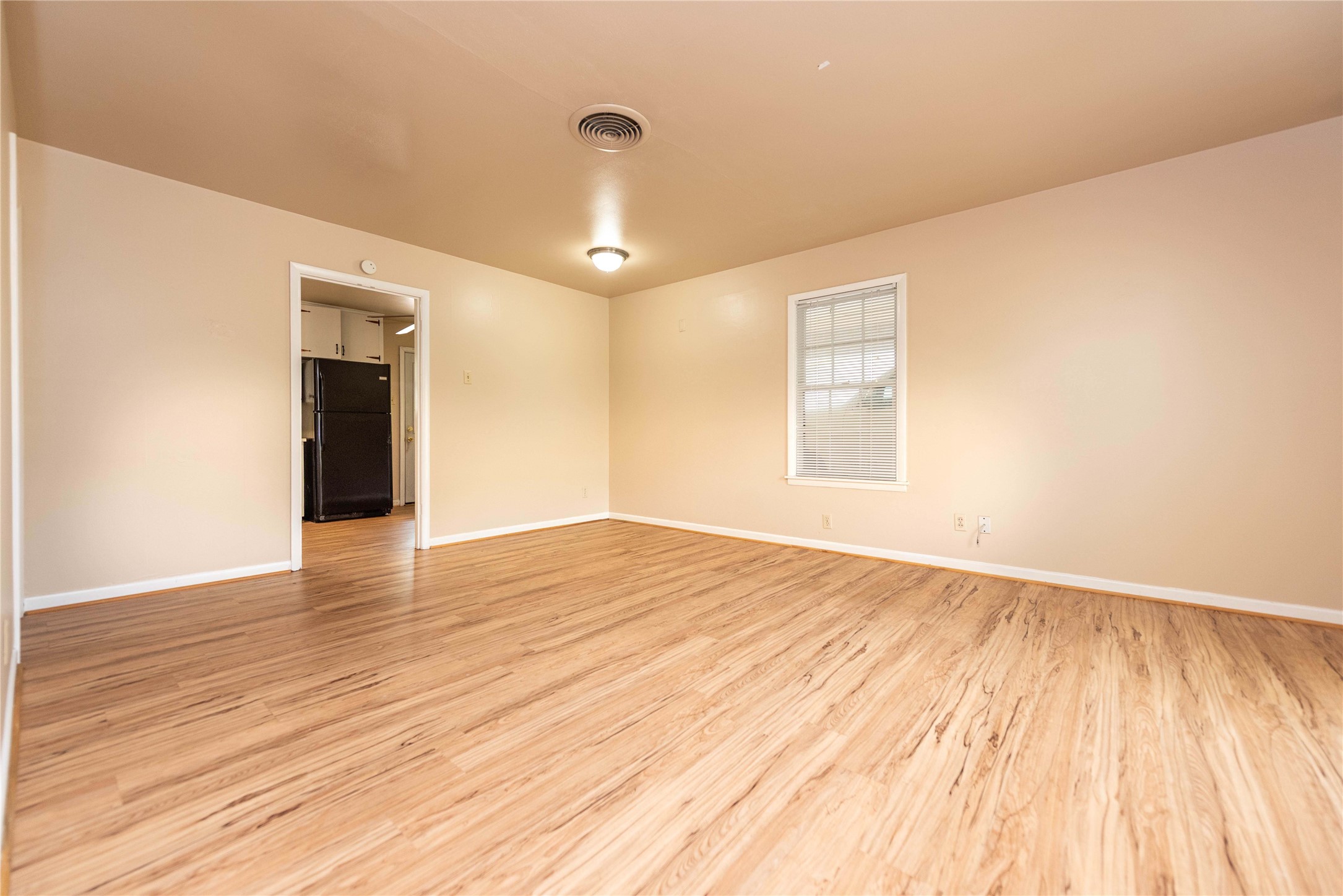 7602 Delafield Lane Austin, TX 78752 - Photo 5 of 17 A well-lit interior with wood-toned flooring and a convenient pass-through to the kitchen area.