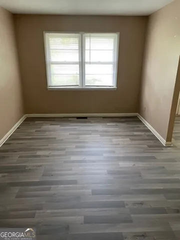 a view of a room with wooden floor and window