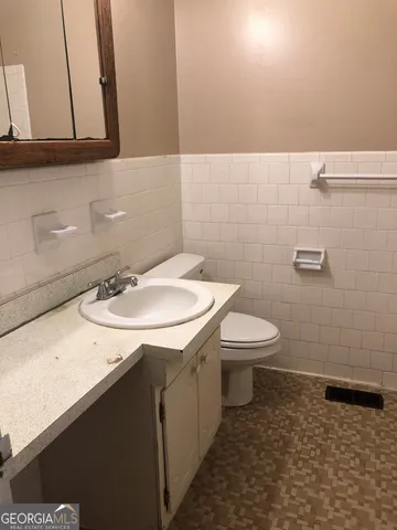 a bathroom with a sink toilet and mirror