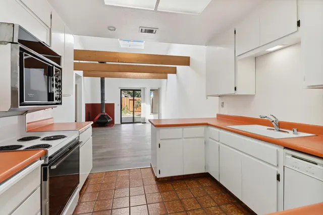 a kitchen with stainless steel appliances granite countertop a sink and dishwasher a stove top oven with wooden floor