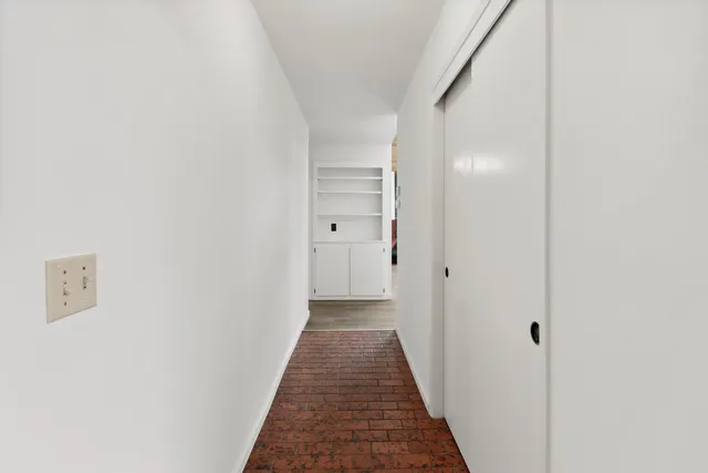 a view of a hallway with wooden floor
