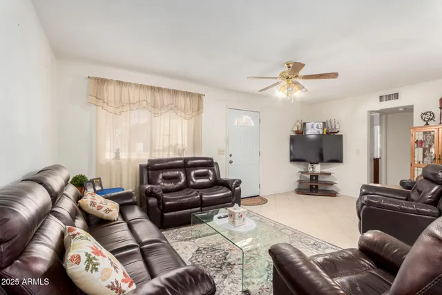 a living room with furniture a ceiling fan and a window