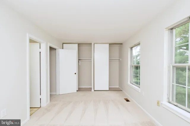 an empty room with windows and closet