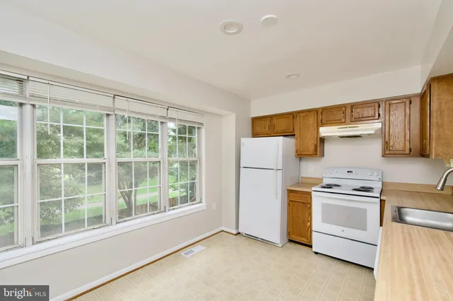 a kitchen with a stove a fridge and a sink