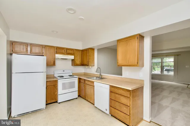 a kitchen with a sink a refrigerator and cabinets