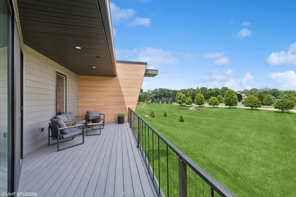 a view of a balcony with chair and wooden floor