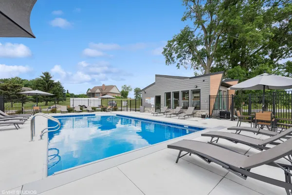 a view of a swimming pool with lounge chairs in patio