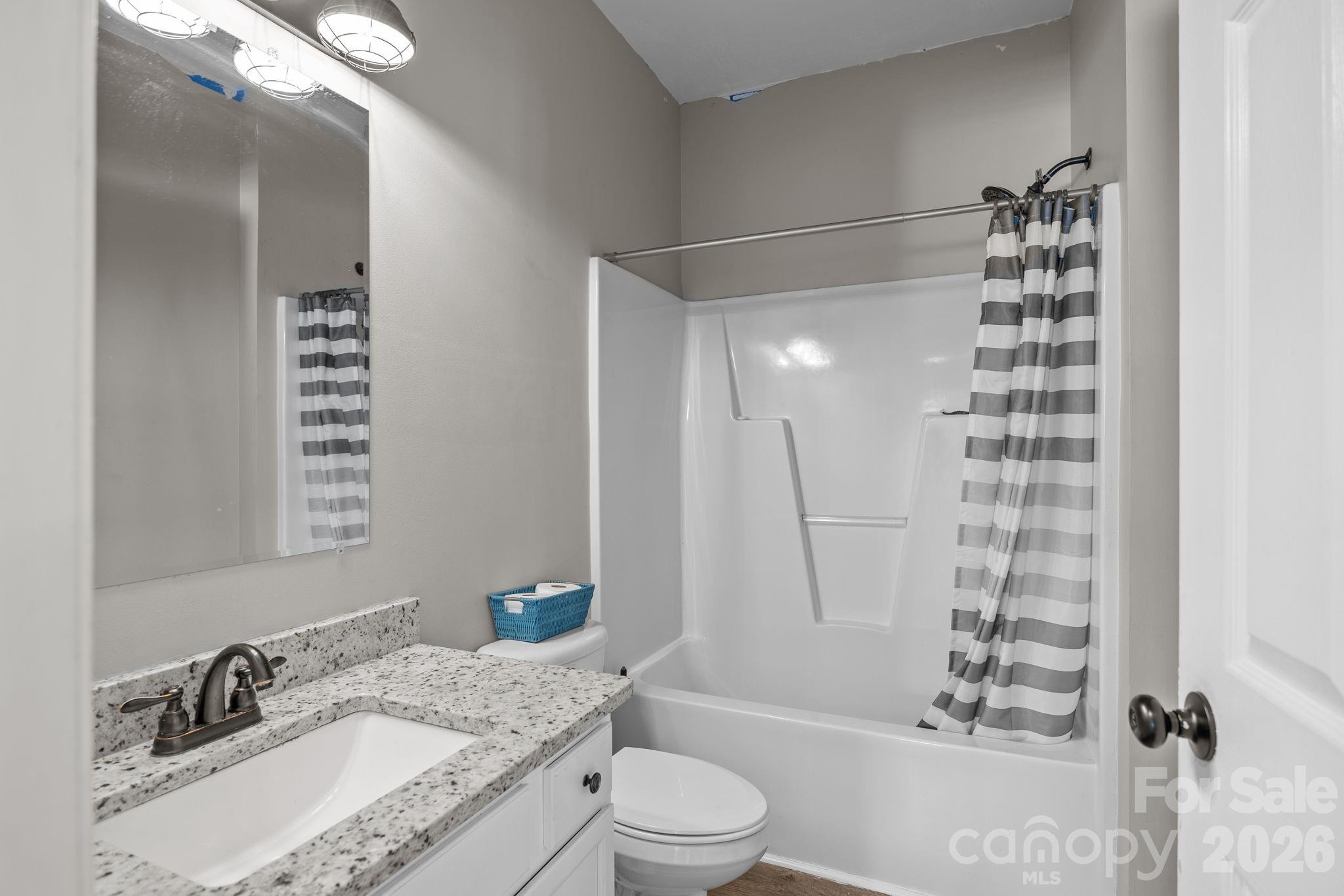 4275 Bethany Church Road Claremont, NC 28610 - Photo 23 of 39 a bathroom with a granite countertop sink toilet a shower and a mirror