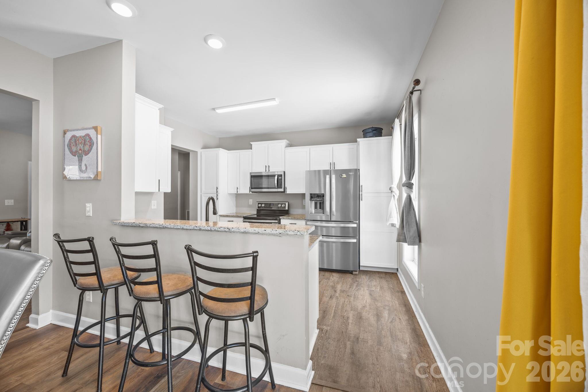 4275 Bethany Church Road Claremont, NC 28610 - Photo 29 of 39 a kitchen with stainless steel appliances a dining table chairs and a refrigerator