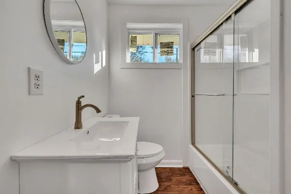 a bathroom with a toilet a sink and mirror