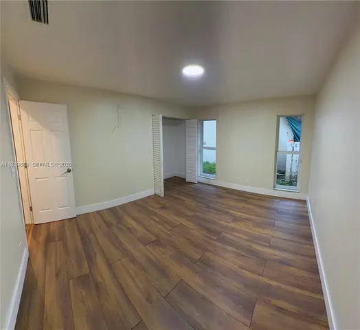 wooden floor in an empty room with a window