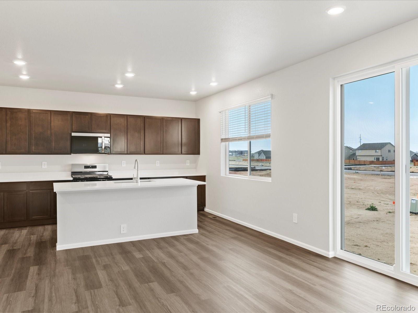 7331 West 27th Street Greeley, CO 80634 - Photo 12 of 40 a large kitchen with stainless steel appliances a large counter top and a stove top oven