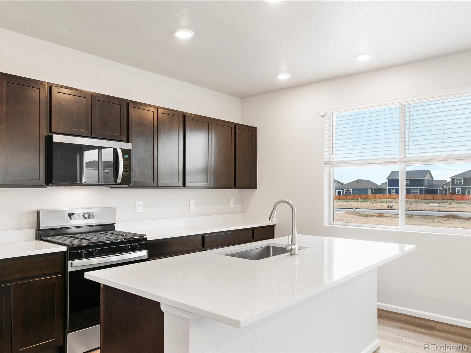 7331 West 27th Street Greeley, CO 80634 - Photo 16 of 40 a kitchen with stainless steel appliances a sink and a stove