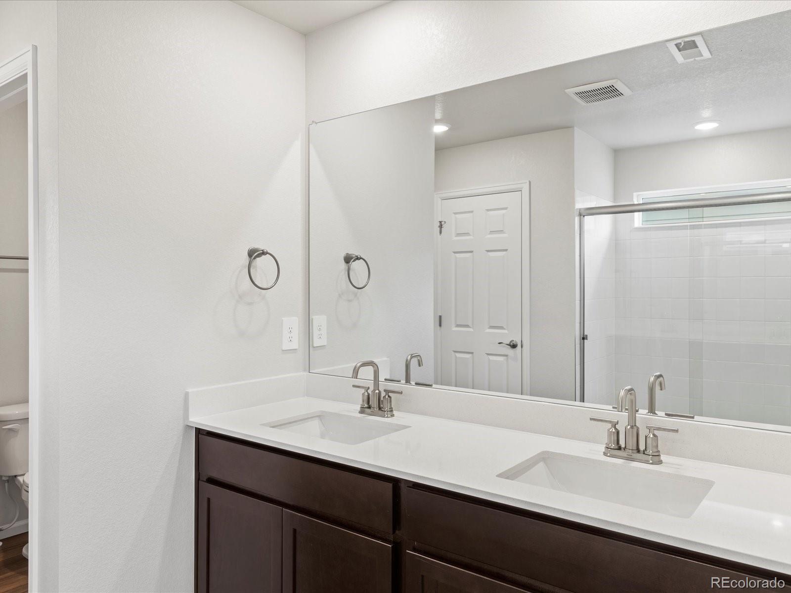 7331 West 27th Street Greeley, CO 80634 - Photo 22 of 40 a bathroom with a sink double vanity and a mirror