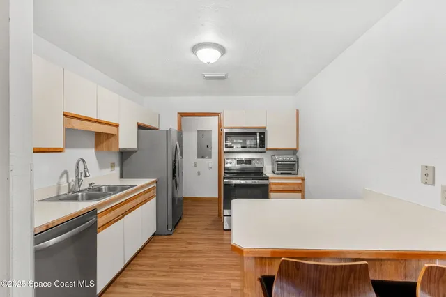 a room with kitchen island stainless steel appliances a stove and more cabinets