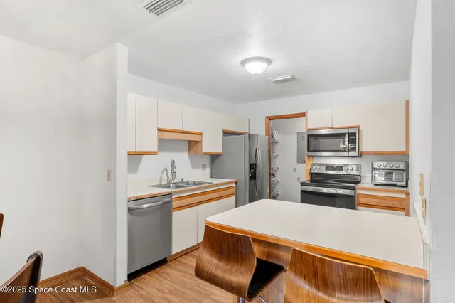 a kitchen with stainless steel appliances a refrigerator and a stove top oven