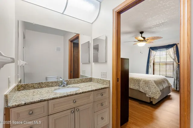 a en suite bathroom with a granite countertop sink and a mirror