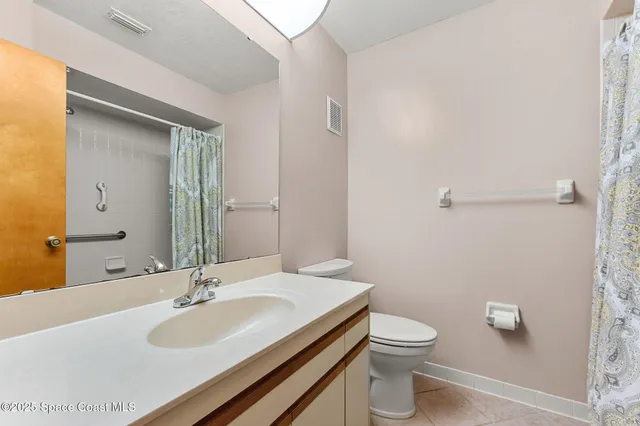 a bathroom with a granite countertop sink toilet and a mirror