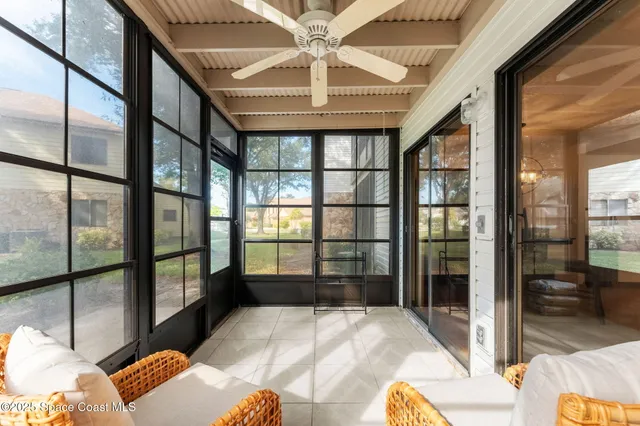 a bedroom with a bed and a large window with the balcony view