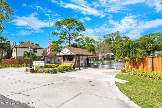 a view of a tennis ground with large trees