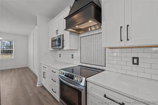 a view of a livingroom with a ceiling fan & windows