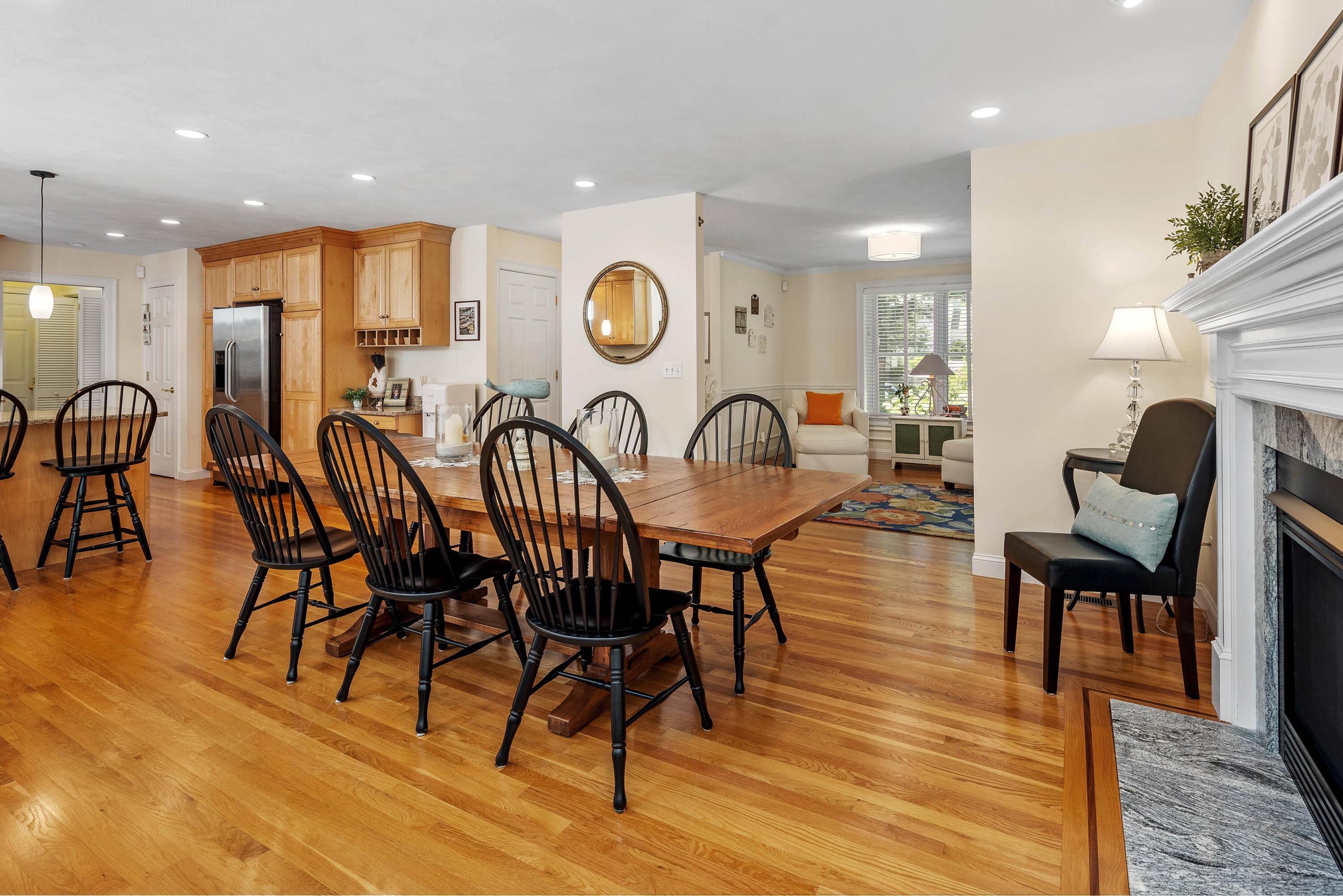 193 Fells Pond Road Mashpee, MA 02649 - Photo 8 of 33 a view of a dining room and livingroom with furniture wooden floor a rug a fireplace and a chandelier