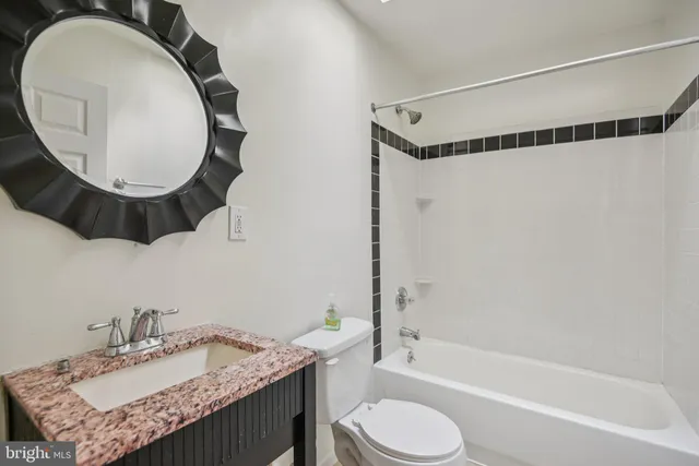 a bathroom with a sink mirror bathtub and toilet