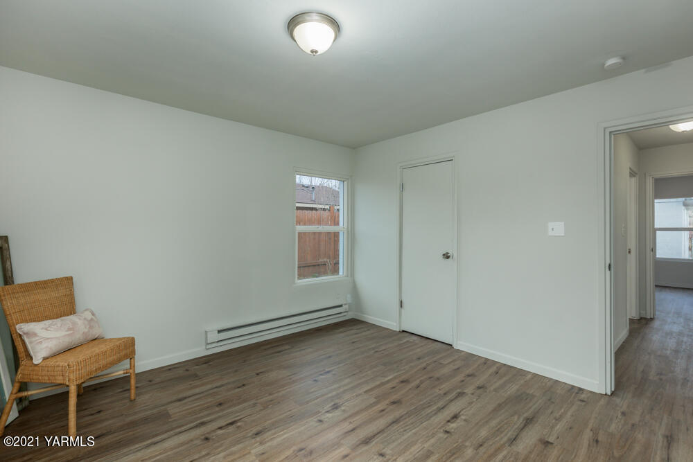 307 Nealy Road Grandview, WA 98930 - Photo 11 of 20 a view of a room with wooden floor a glass table and chair