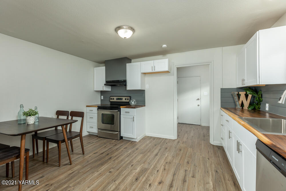 307 Nealy Road Grandview, WA 98930 - Photo 7 of 20 a kitchen with granite countertop white cabinets and stainless steel appliances