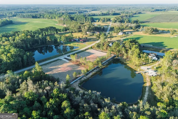 an aerial view of residential houses with outdoor space and lake view