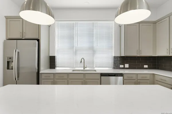 a kitchen with stainless steel appliances kitchen island a refrigerator sink and cabinets