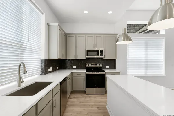 a kitchen with stainless steel appliances a sink stove refrigerator and cabinets