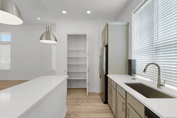 a kitchen with kitchen island a sink appliances and a window