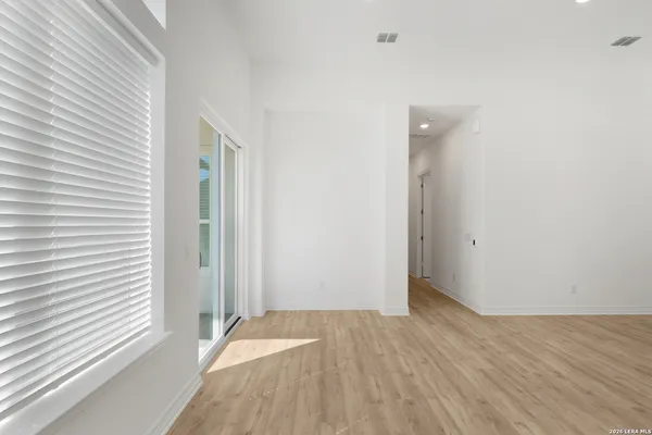 a view of a room with wooden floor and a bathroom