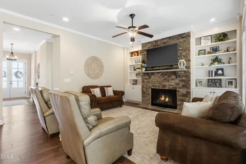 a open kitchen with stainless steel appliances granite countertop a stove a refrigerator a kitchen island a dining table and chairs with wooden floor