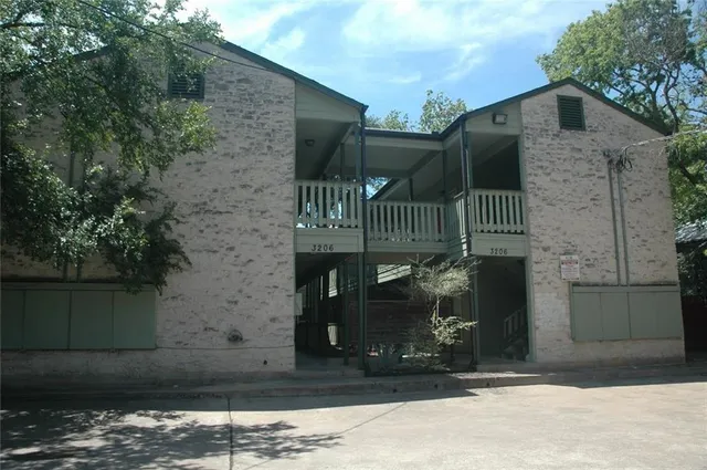 a view of a brick house with iron fence