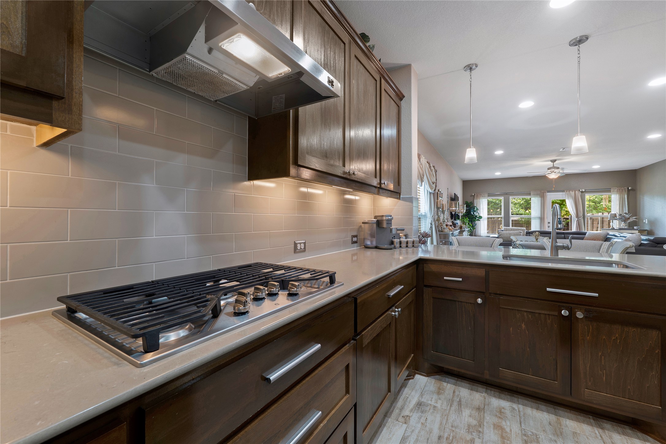 8721 Sikes Way Austin, TX 78747 - Photo 9 of 33 Kitchen featuring dark wood cabinetry, light-toned countertops, and a subway tile backsplash