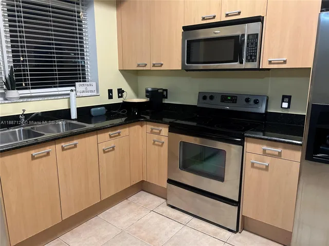 a kitchen with stainless steel appliances granite countertop a stove microwave and sink