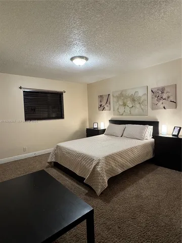 a bedroom with a bed and a night stand