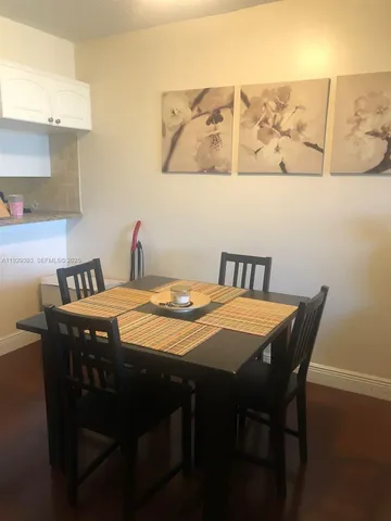 a dining room with a table chairs and wooden floor