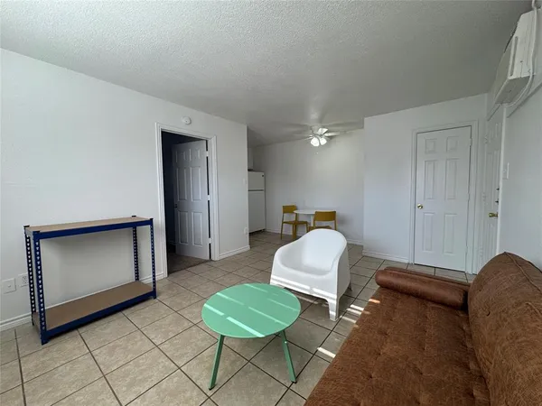 a bedroom with a bed and a refrigerator