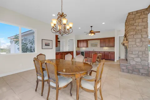 a dining room filled chandelier and wooden floor