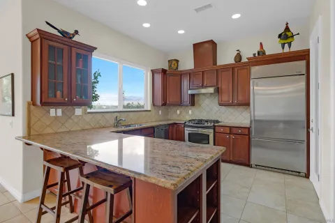 a kitchen with stainless steel appliances granite countertop a sink and a refrigerator