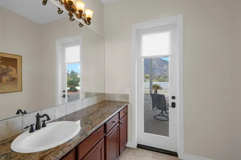 a bathroom with a granite countertop sink a mirror and a shower