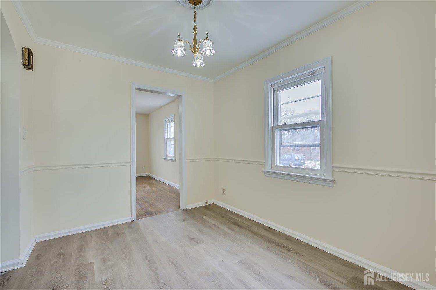 1 Coolidge Avenue Edison, NJ 08837 - Photo 14 of 27 an empty room with wooden floor chandelier and windows