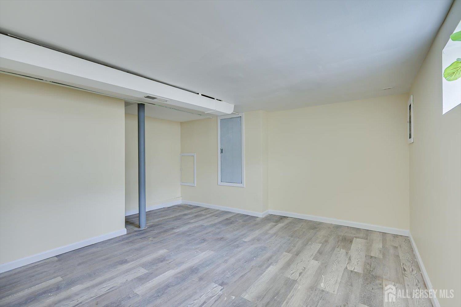 1 Coolidge Avenue Edison, NJ 08837 - Photo 22 of 27 a view of an empty room with wooden floor and a window