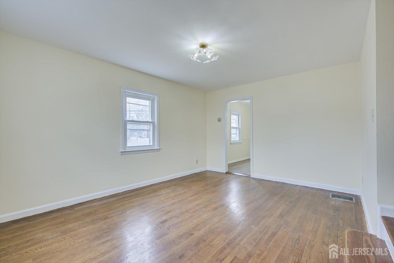 1 Coolidge Avenue Edison, NJ 08837 - Photo 8 of 27 a view of an empty room with wooden floor and a window
