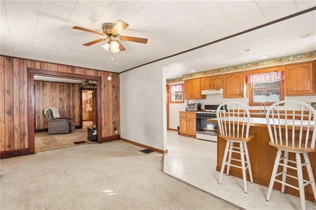 a view of a livingroom with furniture staircase and a ceiling fan